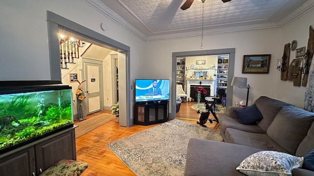 living room featuring crown molding, light wood-type flooring, and ceiling fan