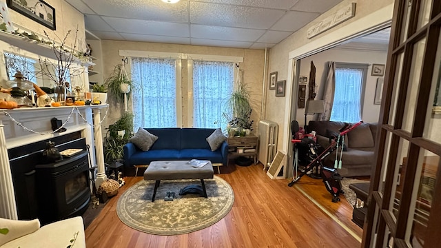 living area with a paneled ceiling and hardwood / wood-style flooring