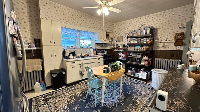 kitchen featuring crown molding, radiator heating unit, stainless steel appliances, and ceiling fan