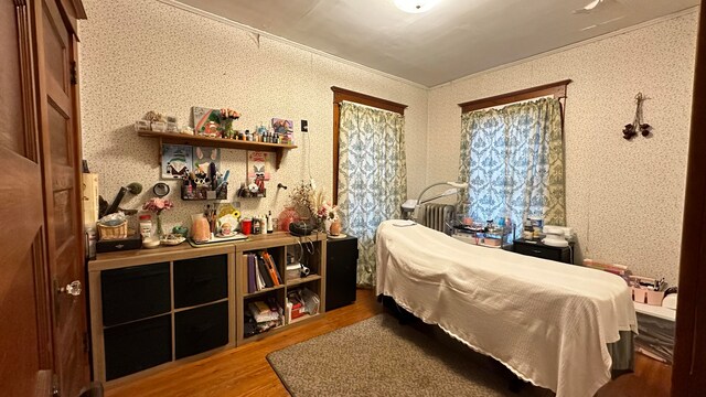 bedroom with ornamental molding and hardwood / wood-style floors