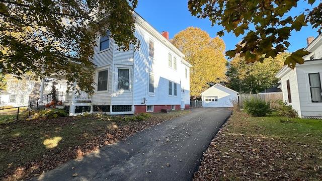 view of side of home with an outdoor structure and a garage