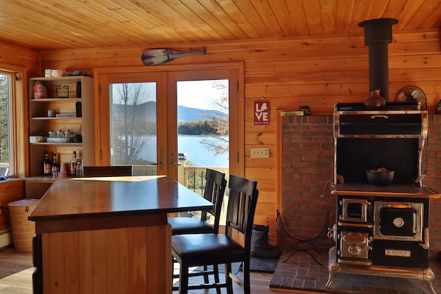 dining room with hardwood / wood-style floors, a water and mountain view, and wood walls