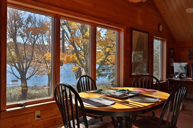 dining room with wood walls, wooden ceiling, and vaulted ceiling