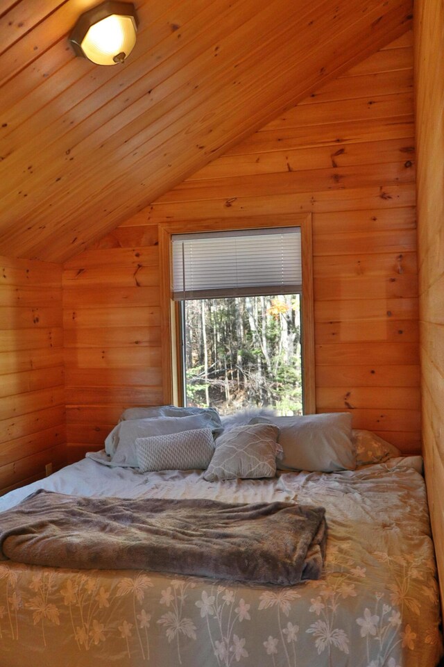 bedroom featuring lofted ceiling, wooden walls, and wooden ceiling