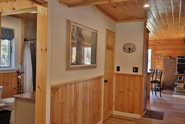 interior space featuring wooden walls, wood ceiling, and light wood-type flooring