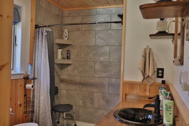 bathroom featuring wood ceiling, sink, wooden walls, and a shower with shower curtain