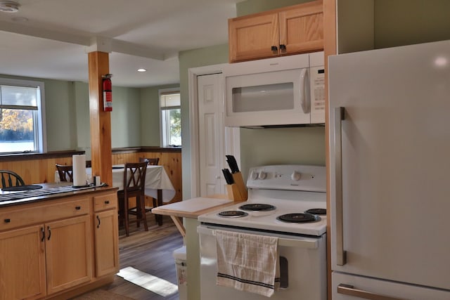 kitchen featuring dark hardwood / wood-style flooring, light brown cabinets, and white appliances