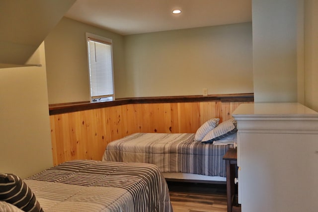 bedroom with wood walls and hardwood / wood-style floors