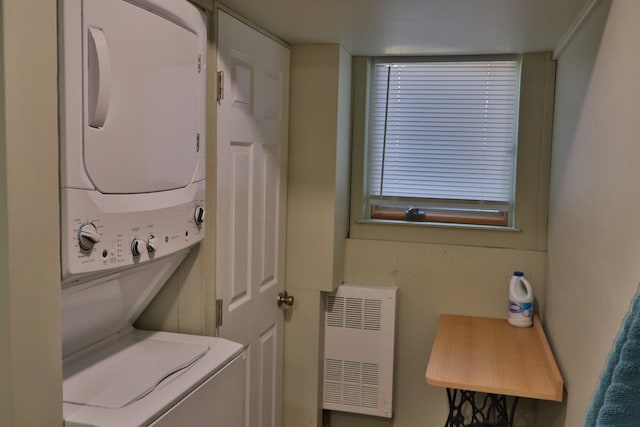 washroom with stacked washer and dryer and radiator