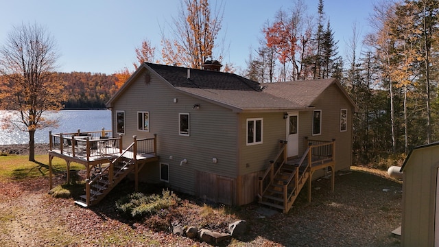 back of property with a deck with water view