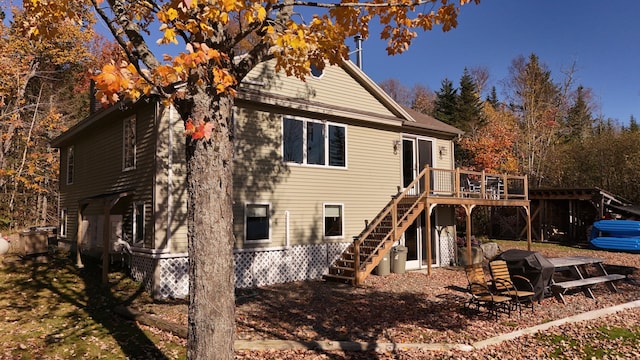 back of house featuring a wooden deck and a fire pit