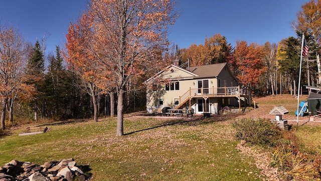 back of house with a deck and a yard