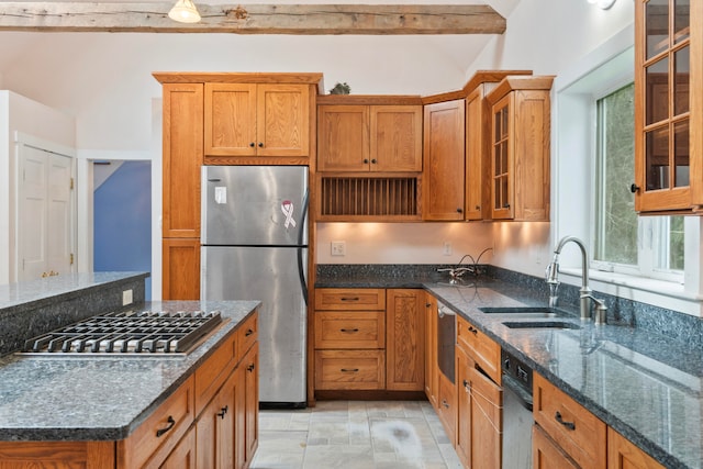 kitchen featuring beamed ceiling, stainless steel appliances, sink, and dark stone counters