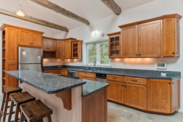 kitchen with beam ceiling, stainless steel appliances, sink, a center island, and a kitchen bar