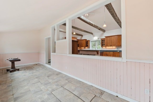 kitchen with vaulted ceiling with beams, kitchen peninsula, pendant lighting, a baseboard radiator, and wood walls