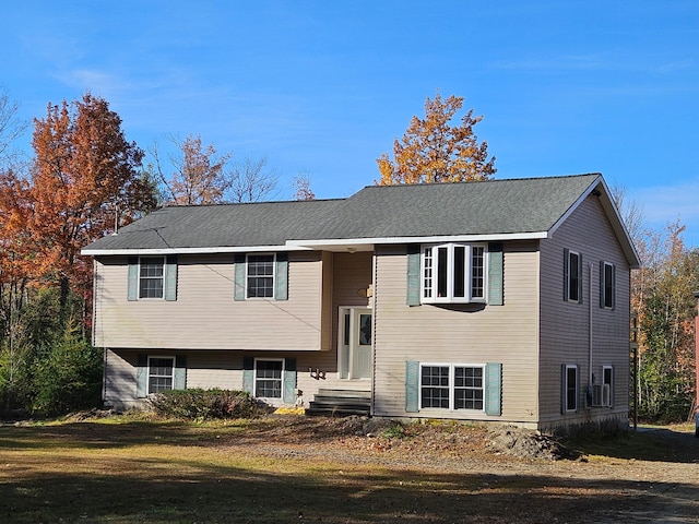 bi-level home with a front yard and cooling unit