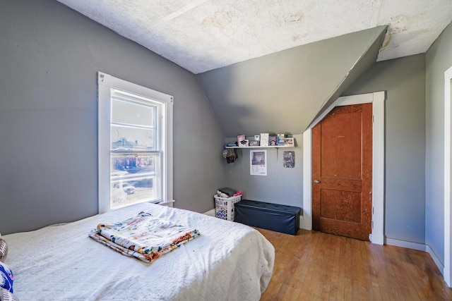 bedroom featuring lofted ceiling and hardwood / wood-style flooring