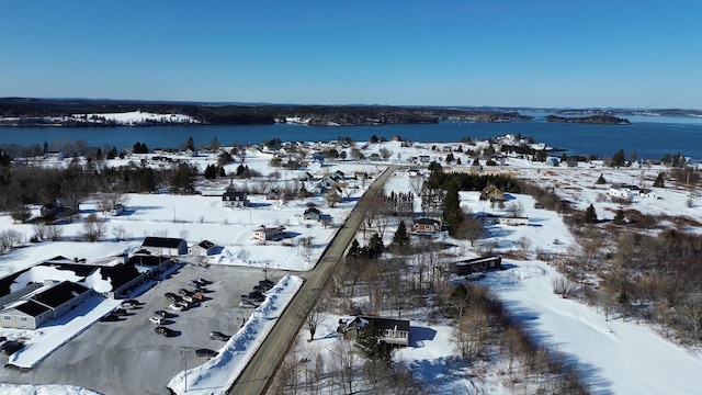 snowy aerial view featuring a water view