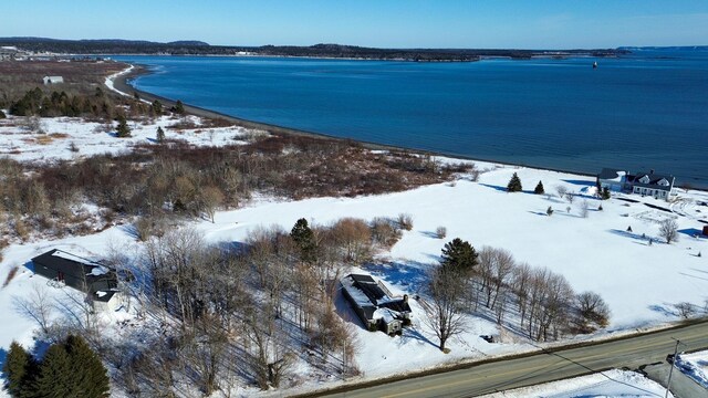 snowy aerial view featuring a water view