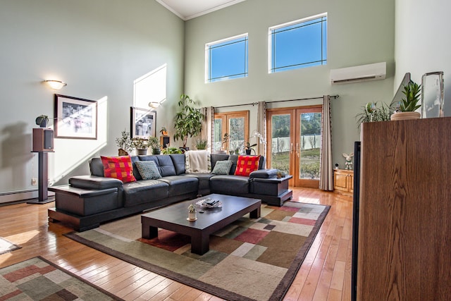 living room featuring a wall mounted AC, french doors, plenty of natural light, and light wood-type flooring