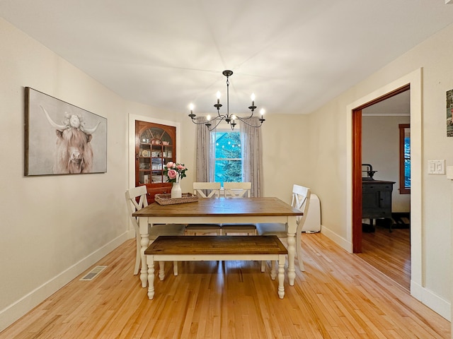 dining space with an inviting chandelier and light wood-type flooring