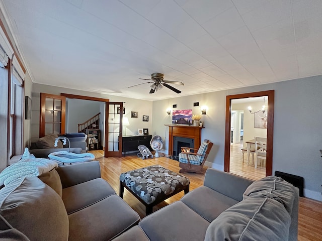 living room featuring crown molding, wood-type flooring, and ceiling fan