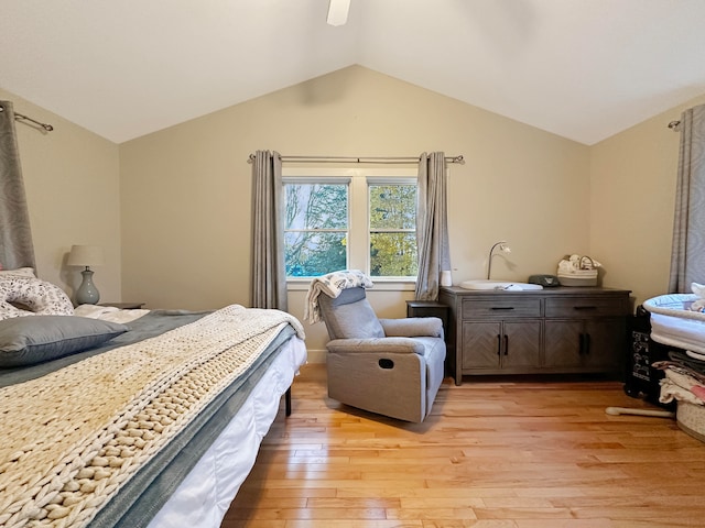 bedroom featuring light hardwood / wood-style floors, vaulted ceiling, and ceiling fan