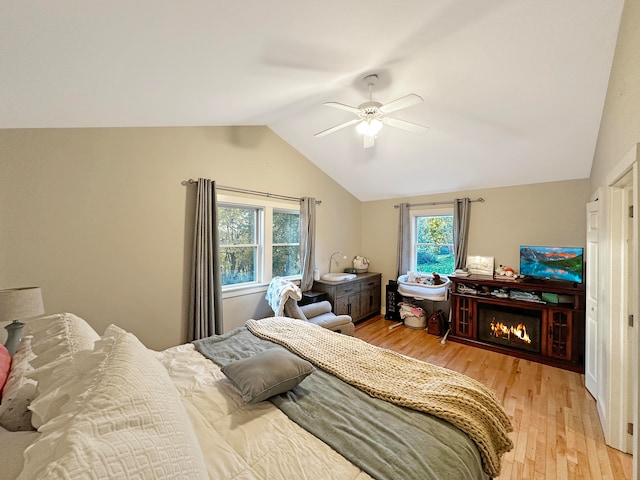 bedroom with vaulted ceiling, light wood-type flooring, and ceiling fan