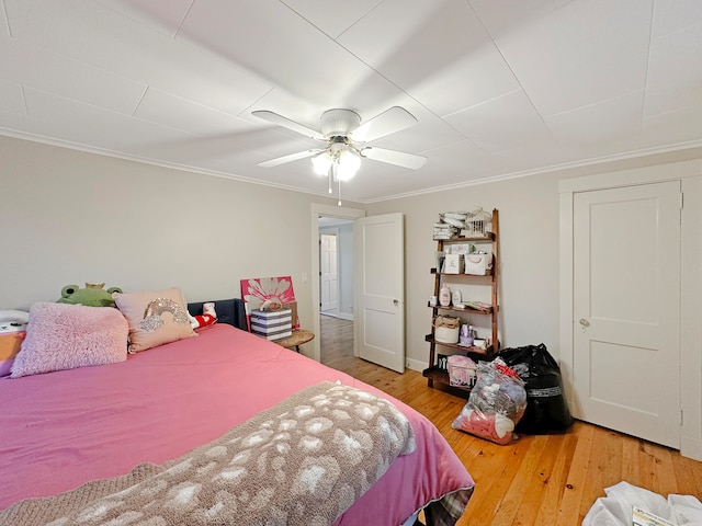 bedroom with ornamental molding, hardwood / wood-style floors, and ceiling fan