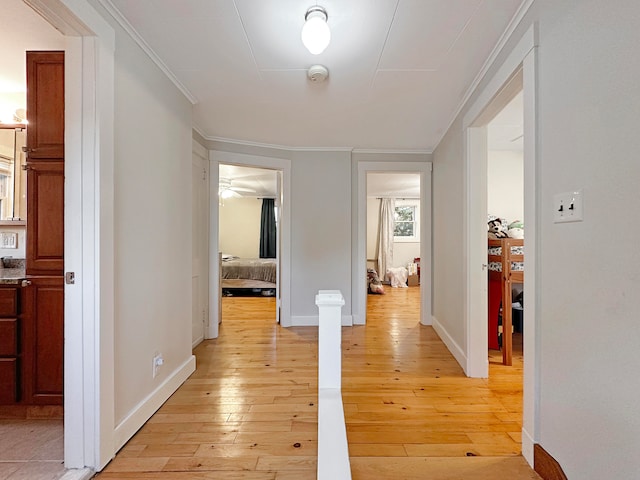 corridor with crown molding and light wood-type flooring