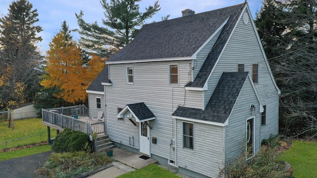 view of front of property with a wooden deck and a front lawn