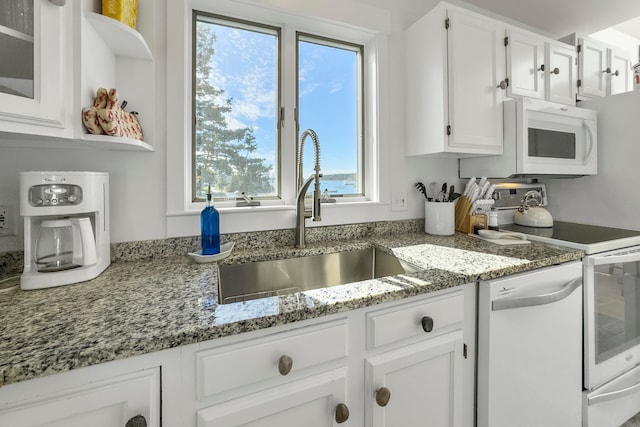 kitchen with stone countertops, appliances with stainless steel finishes, sink, and white cabinets