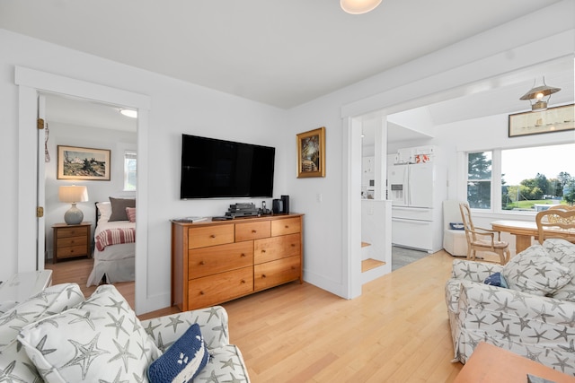 bedroom featuring white fridge with ice dispenser and light hardwood / wood-style floors