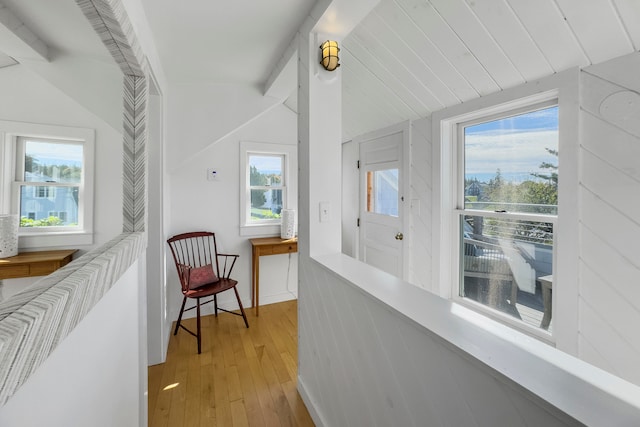 hall featuring vaulted ceiling and light hardwood / wood-style flooring