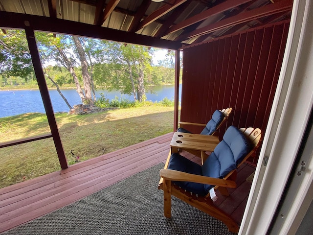 sunroom featuring a water view