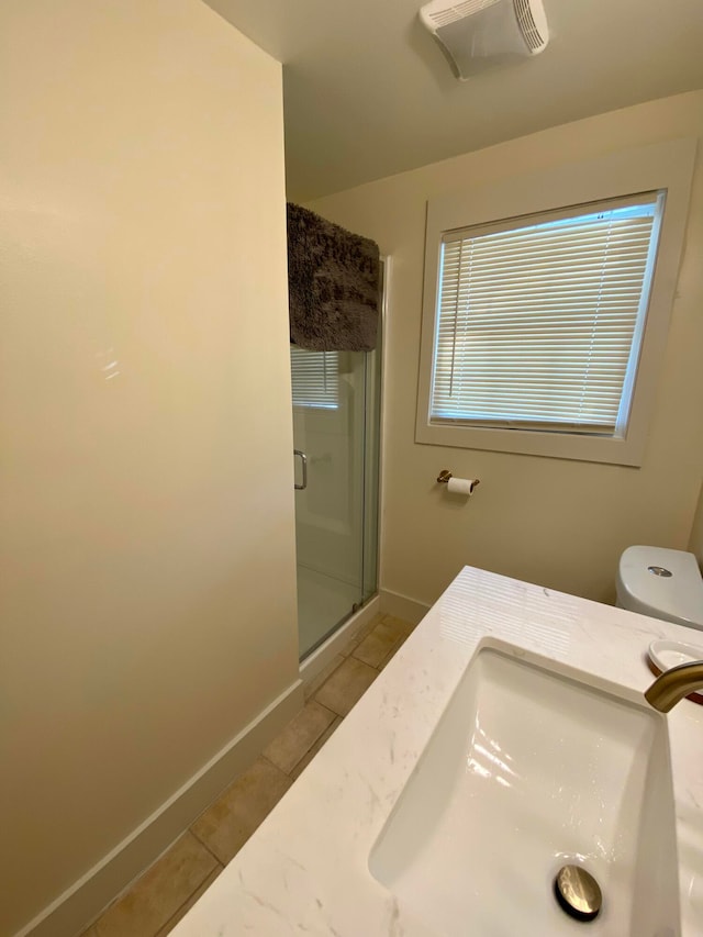 bathroom featuring a shower with door, vanity, toilet, and tile patterned flooring