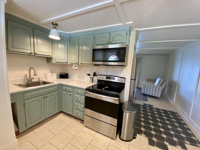 kitchen featuring a sink, light countertops, green cabinets, and appliances with stainless steel finishes