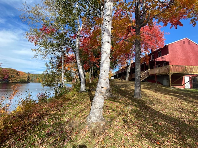 view of yard with a deck with water view