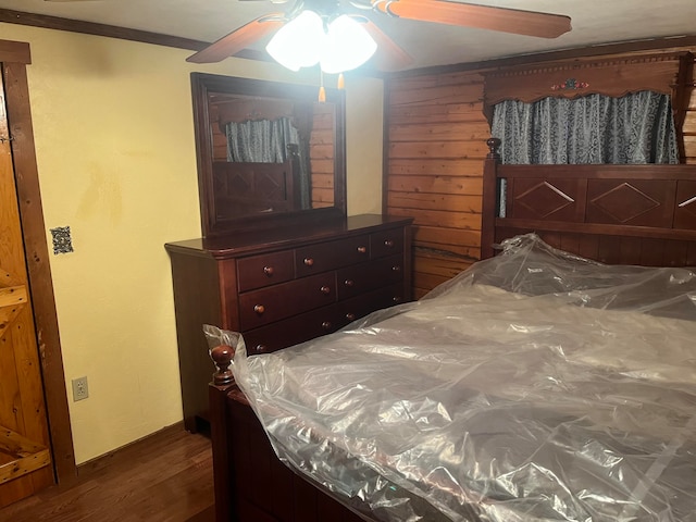 bedroom featuring ornamental molding, dark wood-type flooring, and ceiling fan