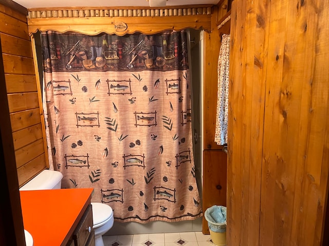 bathroom featuring vanity, toilet, tile patterned floors, and wooden walls