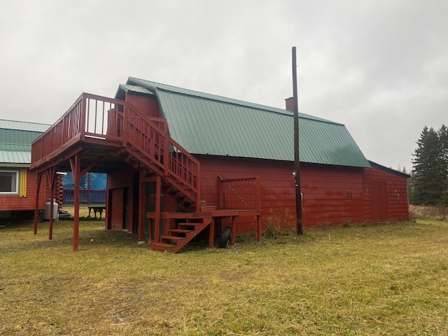 back of house featuring a wooden deck and a yard