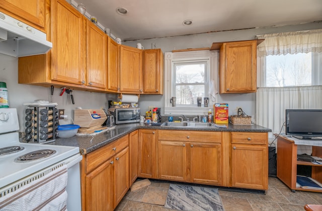 kitchen featuring sink, electric range, and dark stone counters