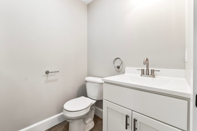 bathroom featuring vanity, hardwood / wood-style flooring, and toilet