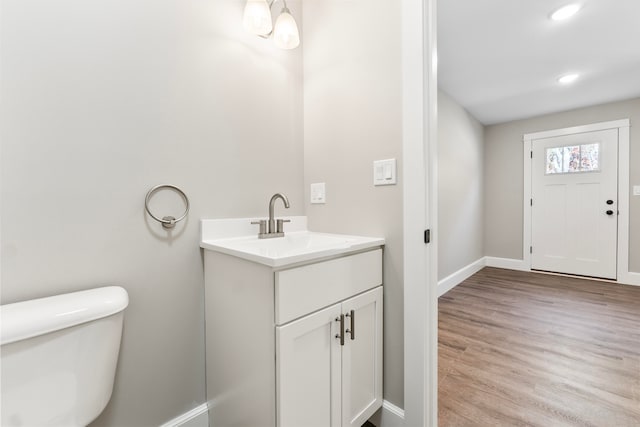 bathroom featuring vanity, toilet, and hardwood / wood-style flooring