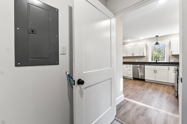 interior space with hardwood / wood-style floors, sink, electric panel, and appliances with stainless steel finishes