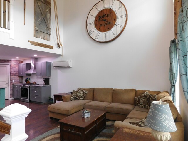 living area featuring dark wood-style flooring and a wall mounted AC