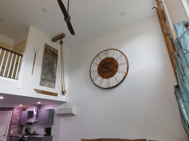 interior details featuring wall chimney exhaust hood, an AC wall unit, and tasteful backsplash