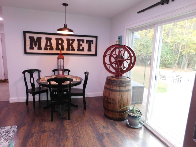 dining area with baseboards and wood finished floors