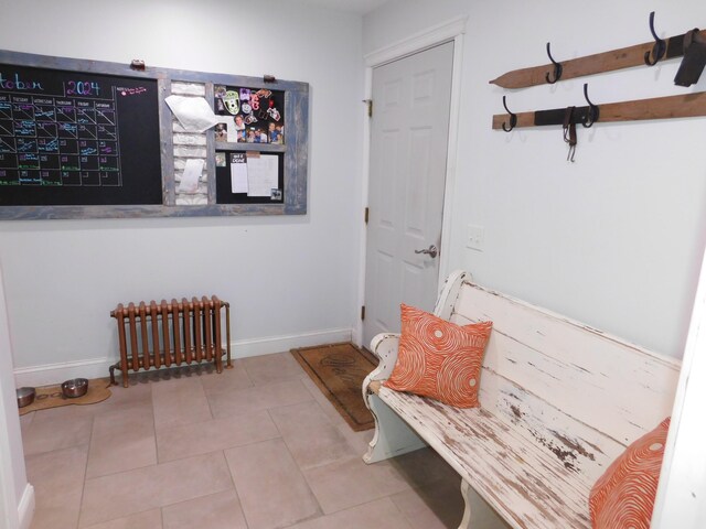 interior space featuring radiator heating unit, baseboards, and tile patterned flooring