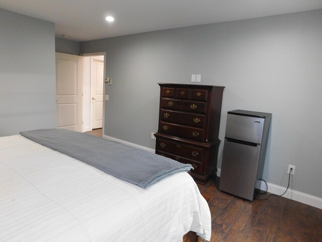 bedroom featuring dark wood-style flooring, recessed lighting, freestanding refrigerator, and baseboards